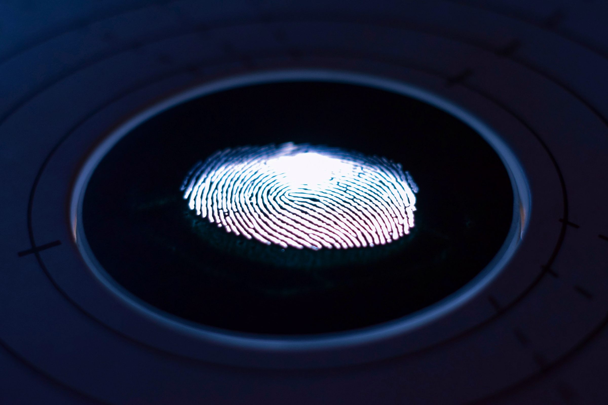 Glowing fingerprint on a dark circular scanner
