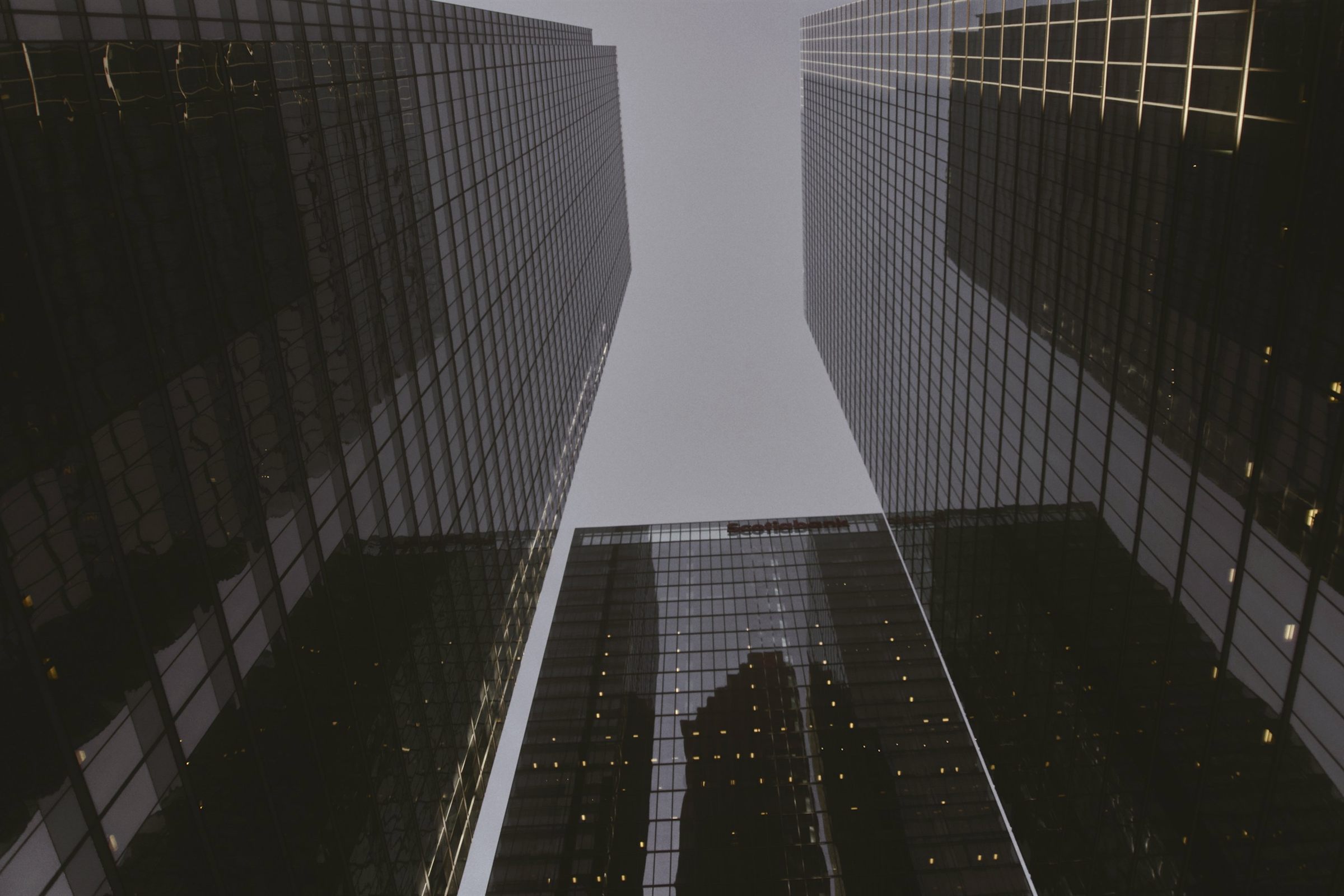 Looking up between dark glass towers in Toronto