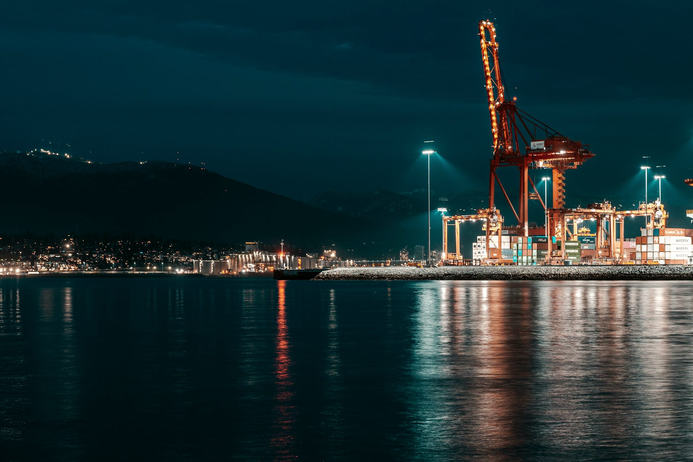 Port of Vancouver container cranes lit at night over the water