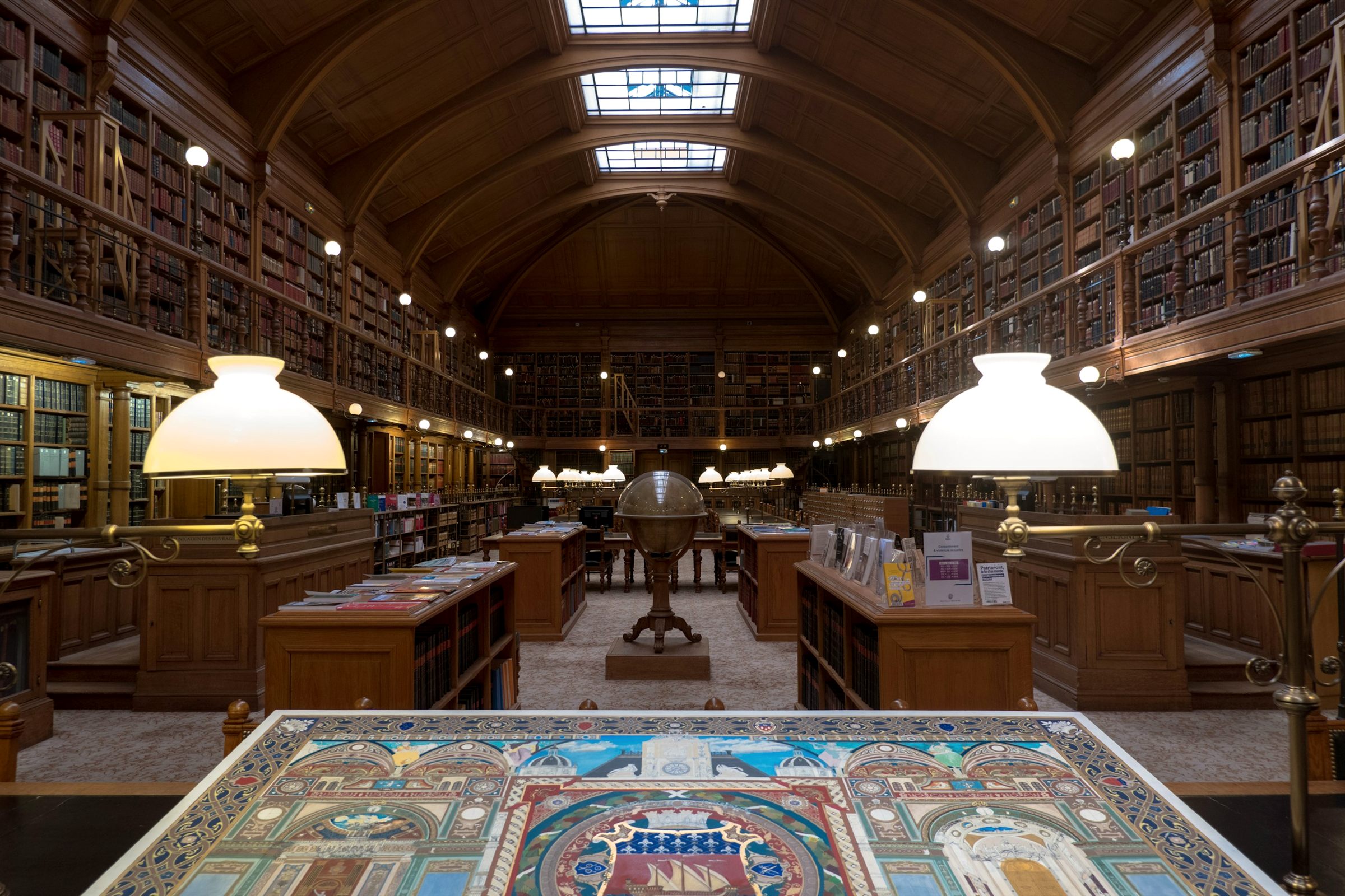 Historic wood-panelled library with desk lamps