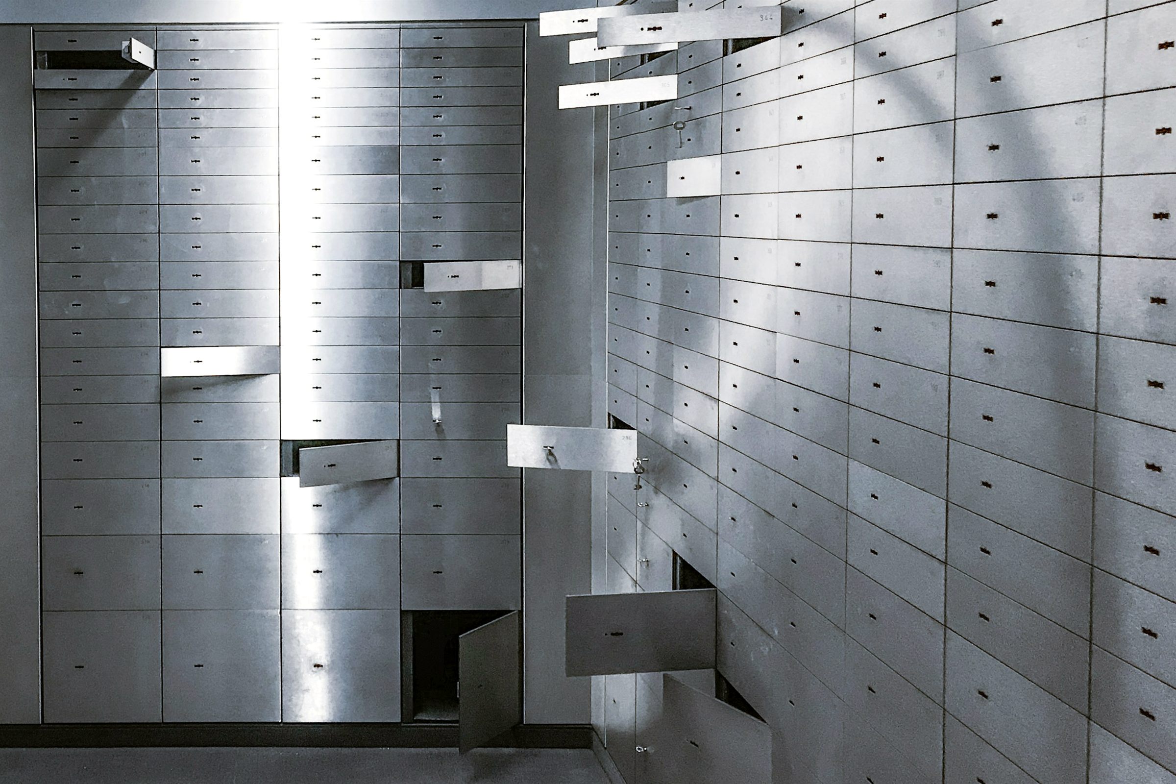 Bank vault room lined with numbered steel safe deposit drawers