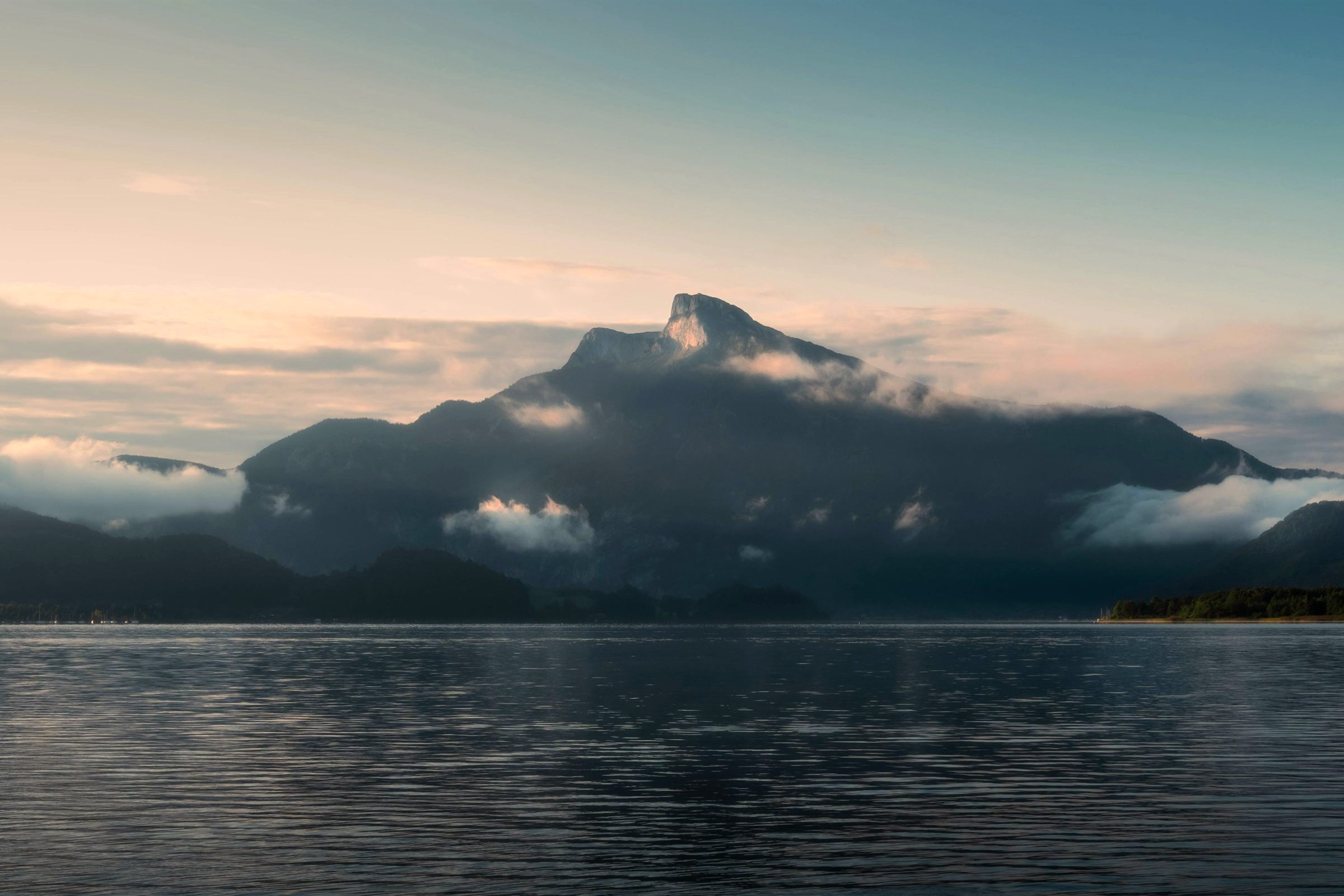 Misty mountains above a calm lake at dawn