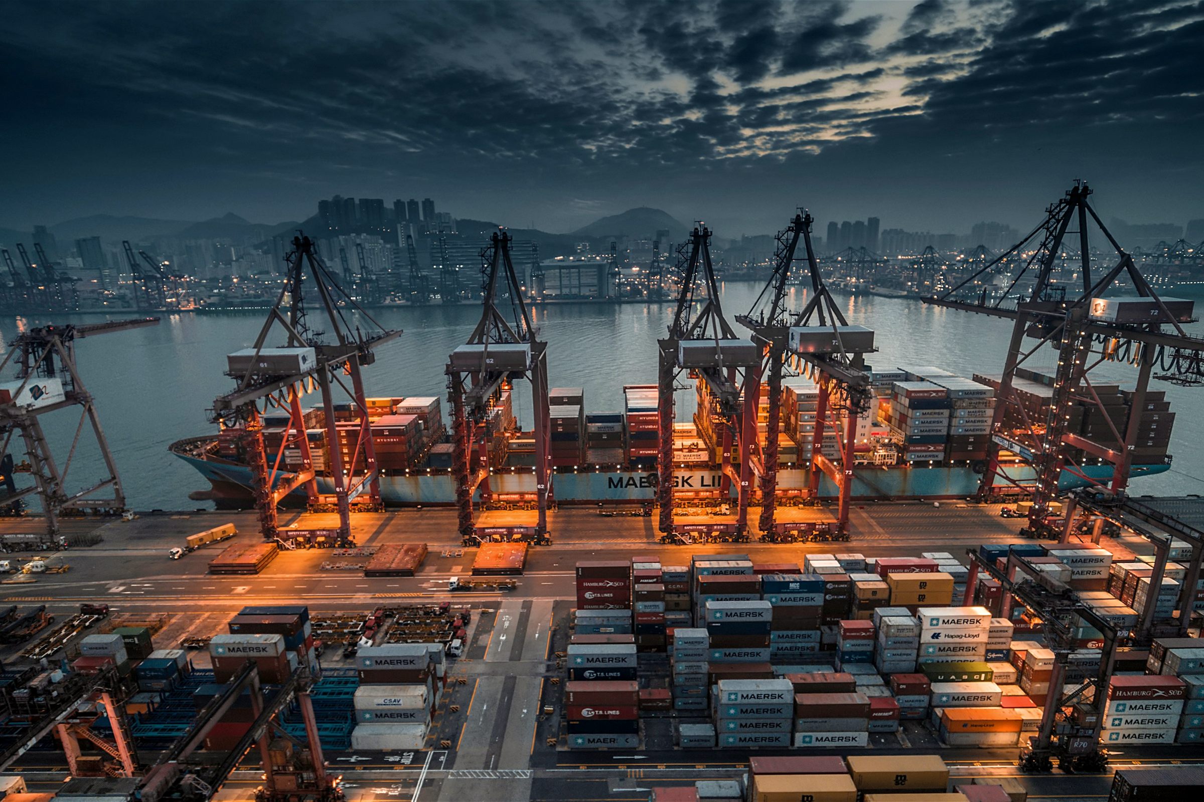 Container port with cranes at dusk